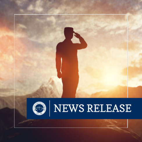 Square photo image of a servicemember saluting with the sun behind the person and blue rectangle graphic with text reading NEWS RELEASE