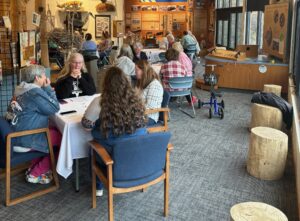 Three tables inside a building with several people around each table playing Bunco