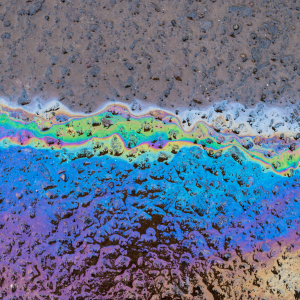 Thin layer of oil on wet asphalt shining with a rainbow effect