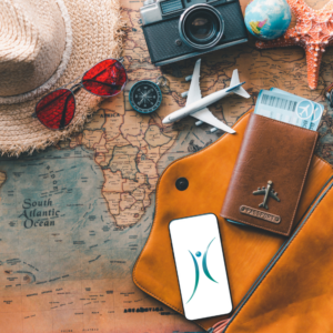 A grouping of items laying on a map that are all travel related. A map, passport cover, camera, toy plane, sunglasses, phone, hat and compass.
