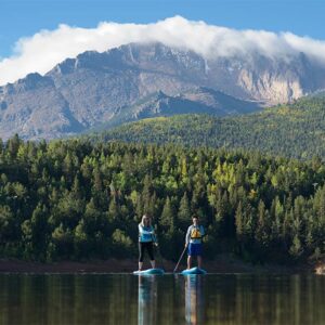 two people on a mountain lake paddle boarding
