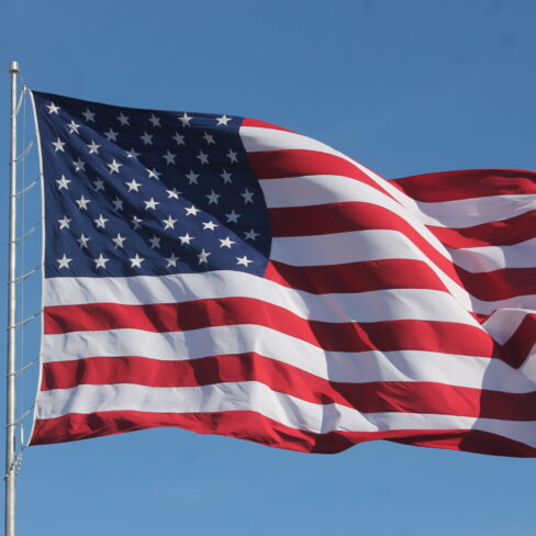 American flag on a flagpole blowing in the wind
