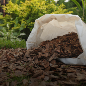 Image of mulch being emptied from a cloth bag into a garden