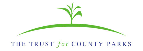 Trust for County Parks Logo Blue text-02 graphic image showing a small green line representing the ground with a green plant sprout in the center. The words The Trust for Count Parks underneath