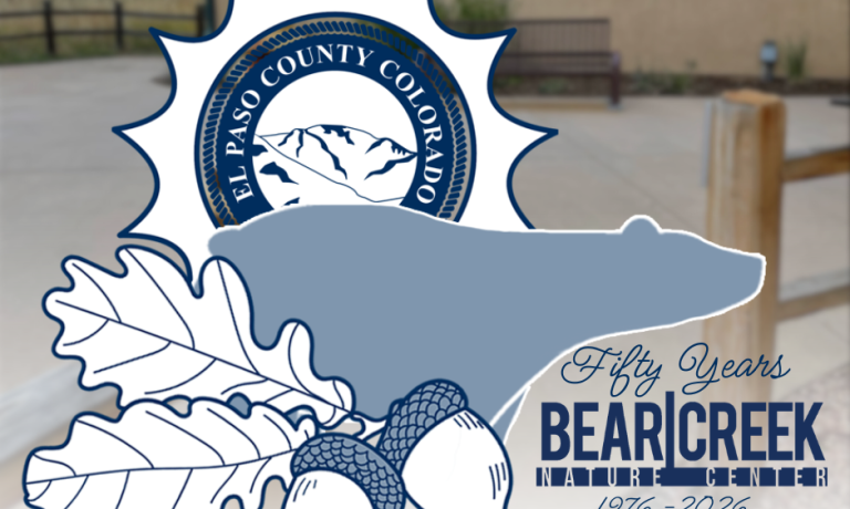 Logo in foreground depicting El Paso County logo wthin a sun, the silhouette of a bear and the text Fifty Years Bear Creek Nature Center 1976-2026. Bear Creek Nature Center building in the background