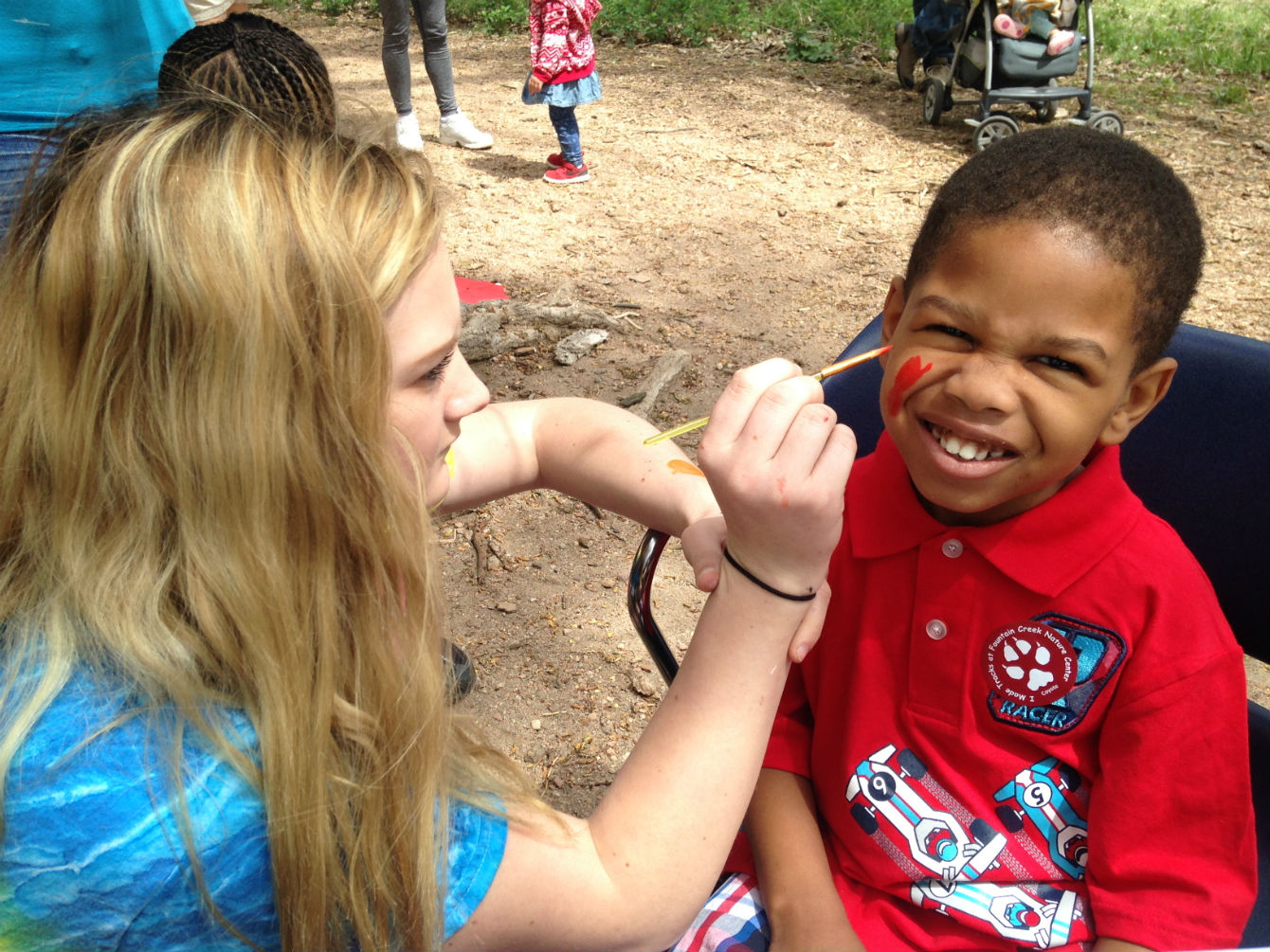 Volunteer painting a childs face