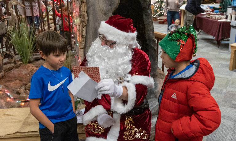 Santa talks to two young boys about their wishlist.
